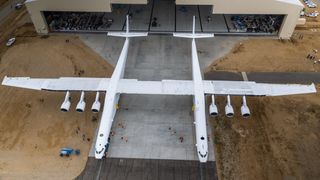 A drone's-eye view of the Stratolaunch Systems carrier plane as it rolls out of its Mojave Air and Space Port hangar for the first time. The plane has a wingspan of 385 feet (117 meters), longer than a football field.