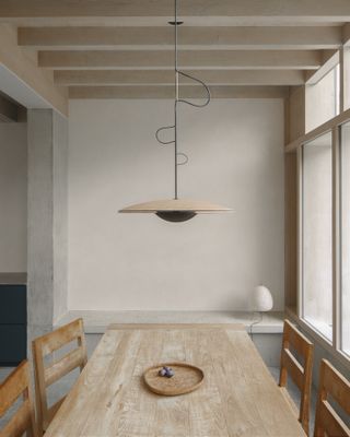 Wooden dining table at Concrete Plinth House by DGN studio