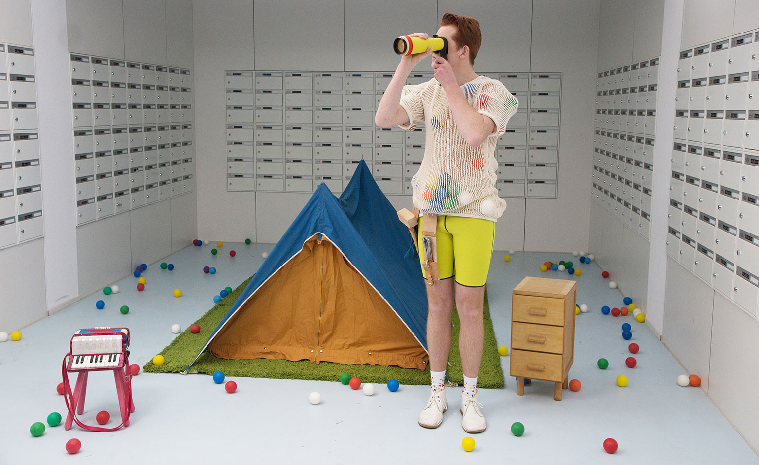 Room includes man, tent, balls, small piano