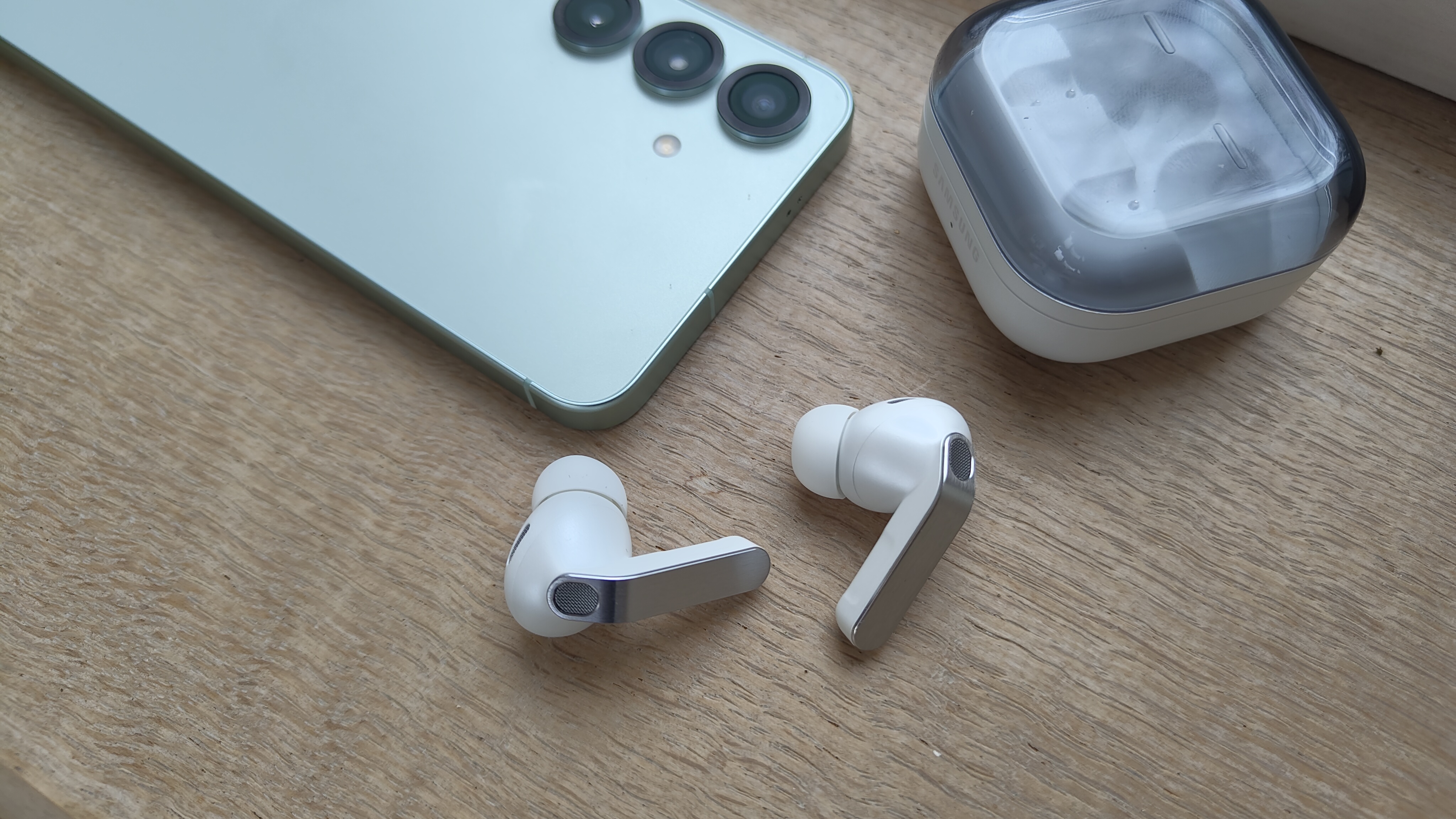 Samsung Galaxy Buds 4 Pro wireless earbuds next to a Samsung S25 smartphone 
