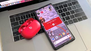 Showing red Beats Studio Buds and Galaxy smartphone displaying shortcut menu