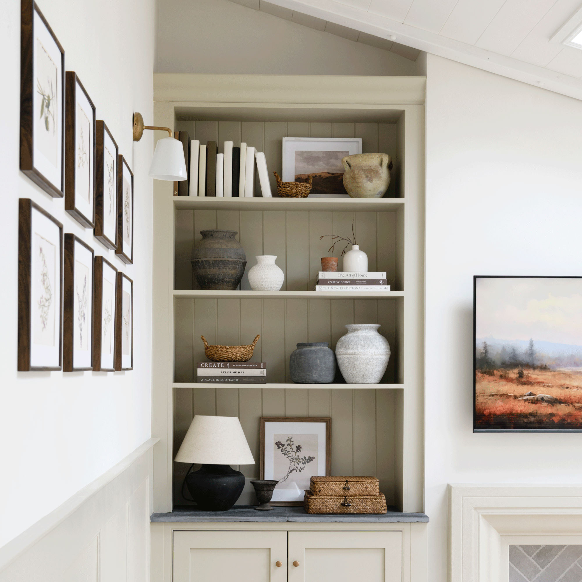 a living room with fitted alcove shelving and artwork on the walls