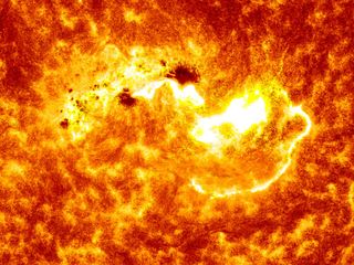 This NASA view combines two images from NASA's Solar Dynamics Observatory captured on Jan. 7, 2014. Together, the images show the location of a giant sunspot group on the sun, and the position of an X-class flare that erupted at 1:32 p.m. EST.