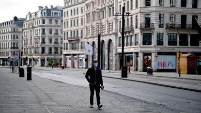 Pedestrian wearing a face mask on a deserted street © TOLGA AKMEN/AFP via Getty Images