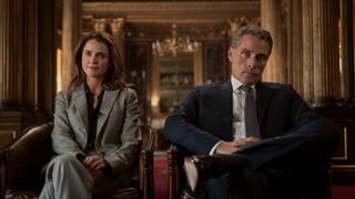 L-R: Kate Wyler (Keri Russell) and Hal Wyler (Rufus Sewell) sit side by side in a first look image for Netflix's "The Diplomat" season 3