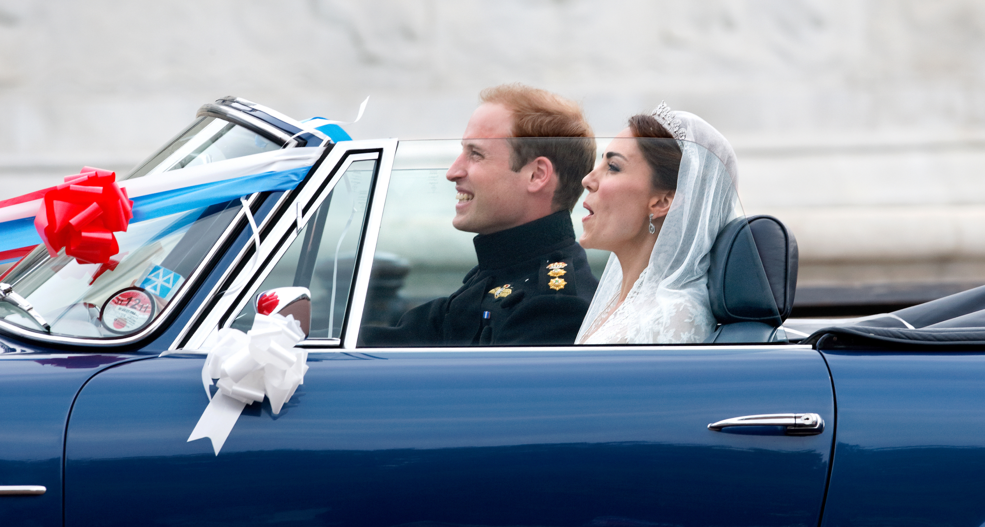 Prince William and Princess Kate riding in a convertible on their wedding day