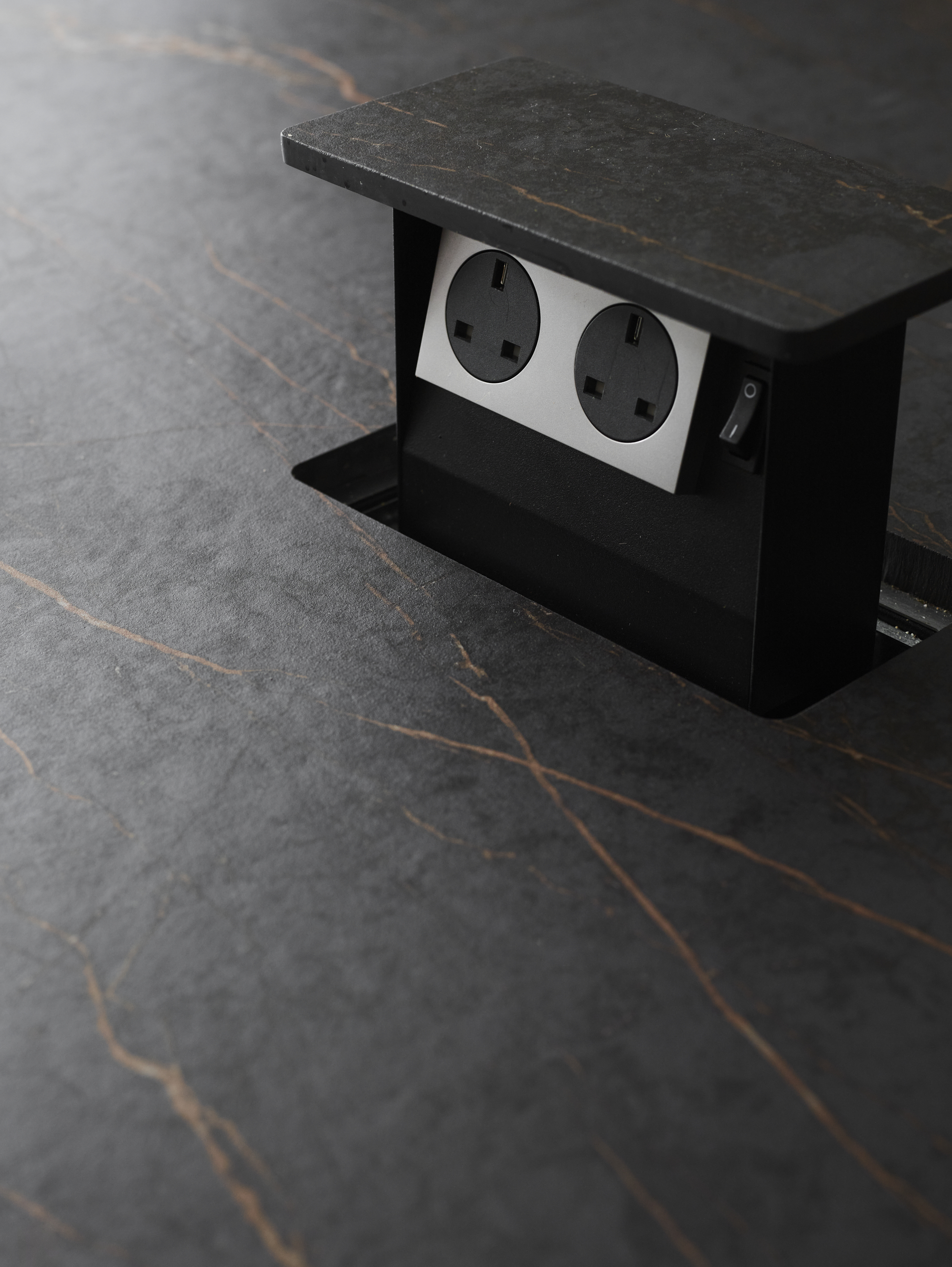 A kitchen with a pop up socket on the countertop