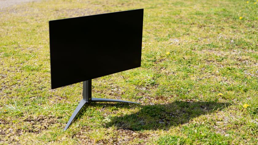 A black Acer Predator X27U monitor sitting on a sunny grass field