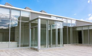 The front of a single storey building with glass panes as the walls.
