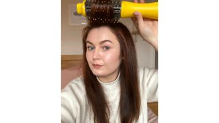 Freelance beauty editor Lucy demonstrating how to style curtain bangs with a blow dryer brush