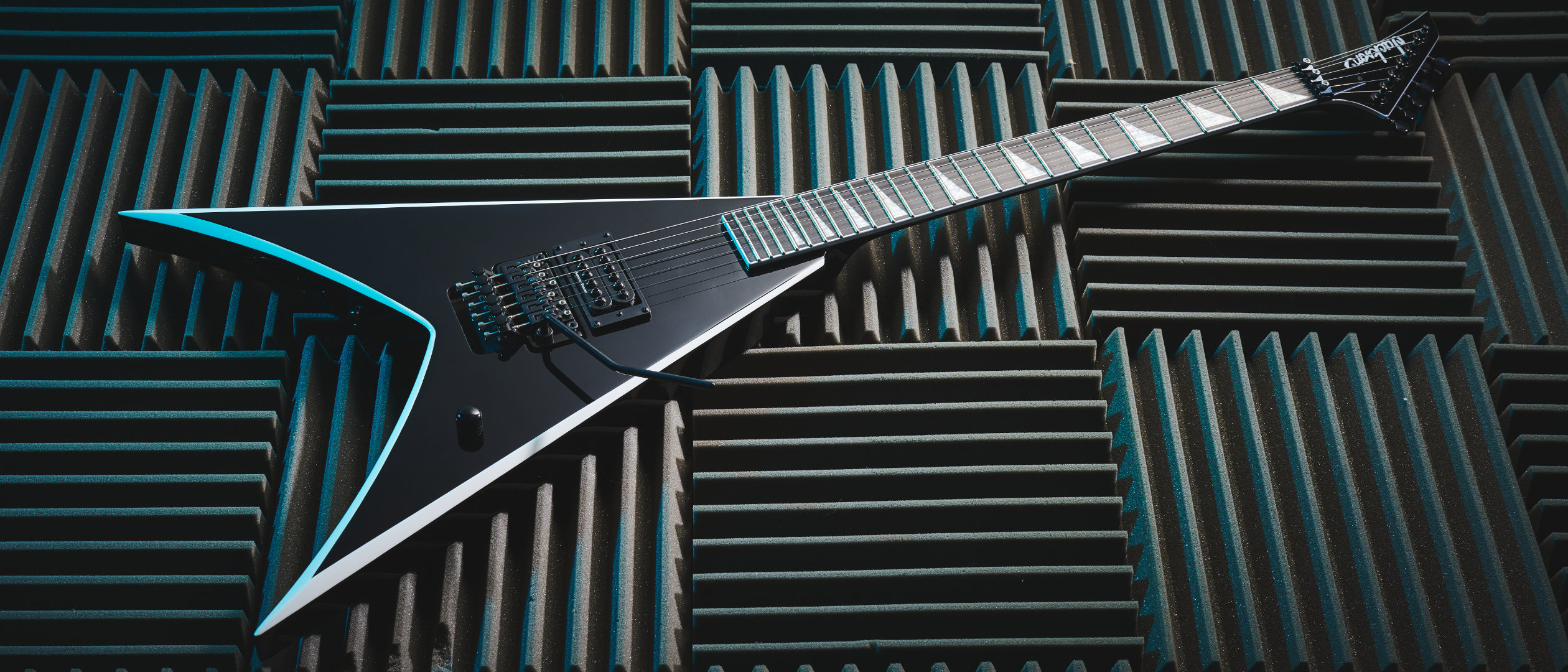 A Jackson Pro Series Signature Wes Borland King V electric guitar lying on panels of acoustic treatment