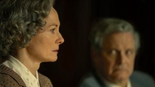 (L-R) Jane Swire (Catherine McCormack) and Jim Swire (Colin Firth) sitting side-by-side in a meeting in "Lockerbie: A Search for Truth"