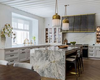 White kitchen with marble island and beamed ceiling painted white