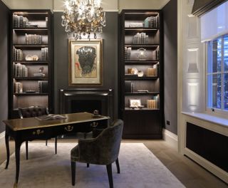 Home office with console desk, side chair, built-in shelving and chandelier