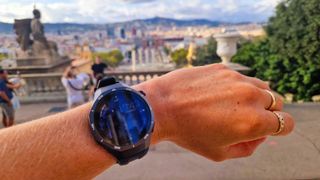 Huawei Watch GT 5 Pro rundt et håndledd, med Barcelona by i bakgrunnen.