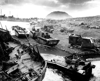 Smashed by Japanese mortar and shellfire, trapped by Iwo's treacherous black-ash sands, amtracs and other vehicles of war lay knocked out on the black sands of the volcanic fortress. c. February/March 1945