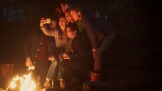 A gang of young campers takes a selfie by the fire in In A Violent Nature.