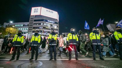 Police block protesters marching against the martial law imposed by South Korean President Yoon Suk-yeol.