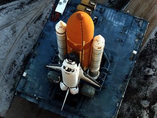 Carried by its mobile launcher platform, shuttle Discovery slowly moves through the high bay doors of the Vehicle Assembly Building on the way to Launch Pad 39A before the STS-82 mission. A seven-member crew performed the second servicing of the orbiting