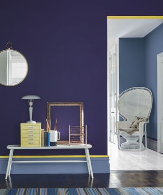 An eggplant purple wall with yellow painted trim