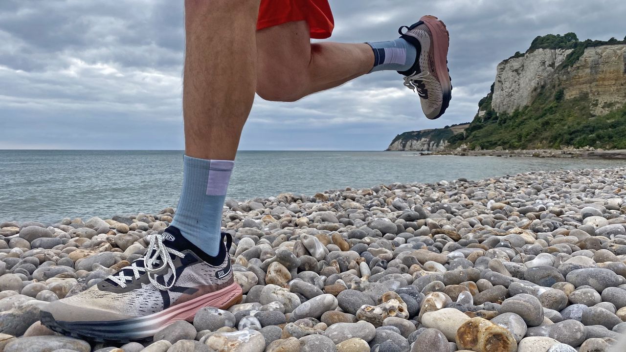 Runner wearing Keen Seek shoes on a pebble beach