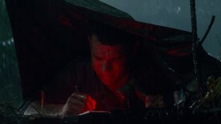 Tom Hanks in a tent with a red light on, writing a letter in Forrest Gump