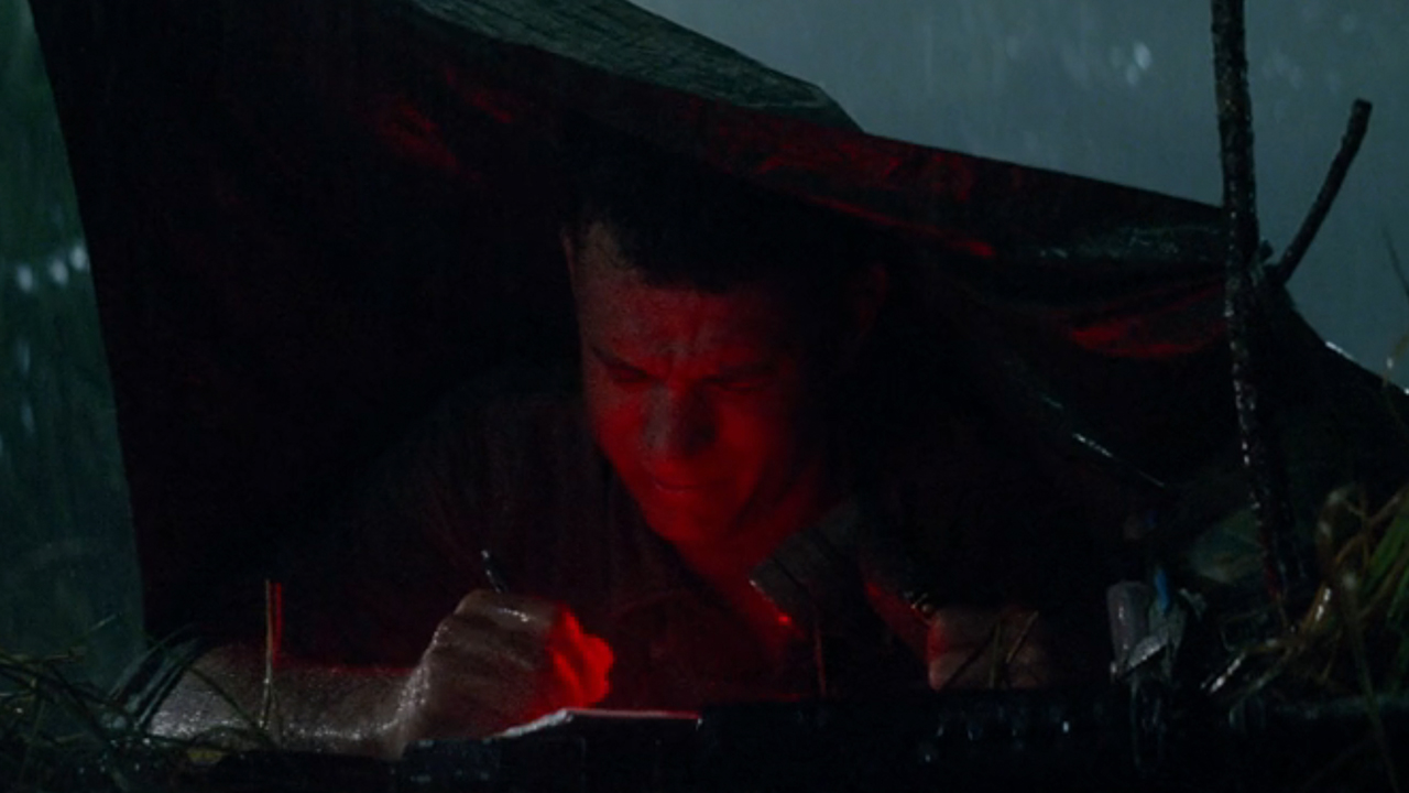 Tom Hanks in a tent with a red light on, writing a letter in Forrest Gump