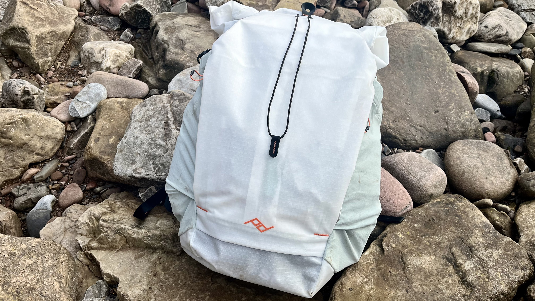 A Peak Design Outdoor Backpack on a pile of rocks.