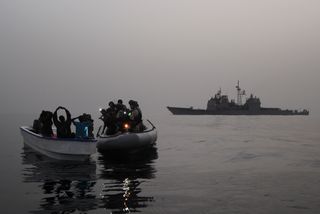 A visit, board, search and seizure team assigned to the guided-missile cruiser USS Anzio (CG 68) investigates a suspected pirate skiff in the Red Sea, Gulf of Aden, Somali Basin and Arabian Sea.