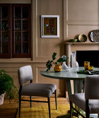 round green dining table, upholstered chairs and yellow rug