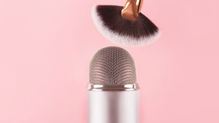 makeup brush and a professional microphone on pink backround. Making ASMR sounds