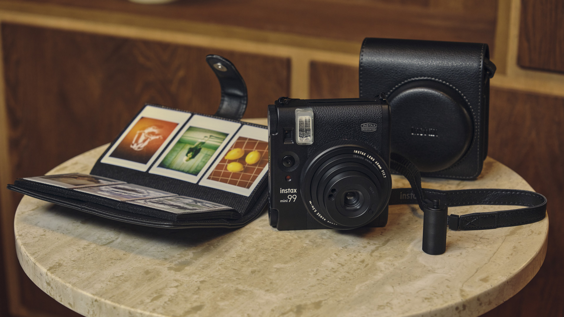 Fujifilm Instax Mini 99 on marble table with mini photo leather album and case