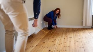 Woman measuring room with partner