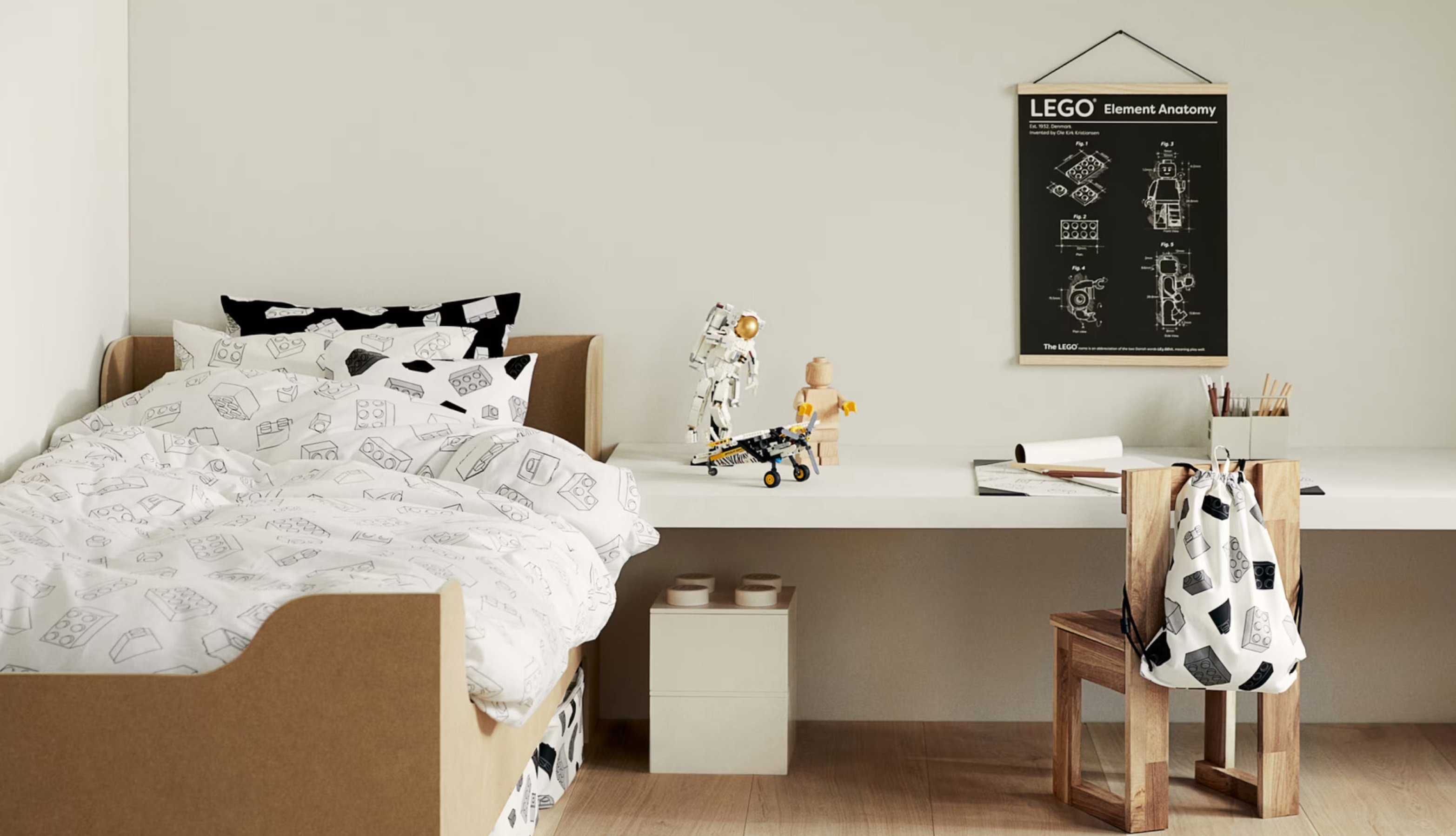 Child&#039;s bedroom in monochrome design with light woods. A lego astronaut stands on the desk.