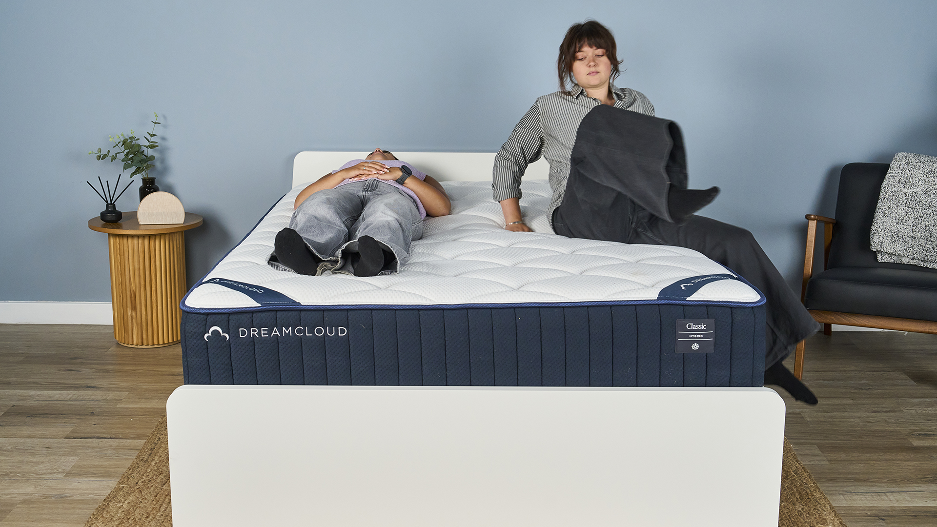 A Tom&#039;s Guide tester lies on their back on the DreamCloud Classic mattress. Another tester is getting into bed to determine how much motion is absorbed in a real-life scenario.