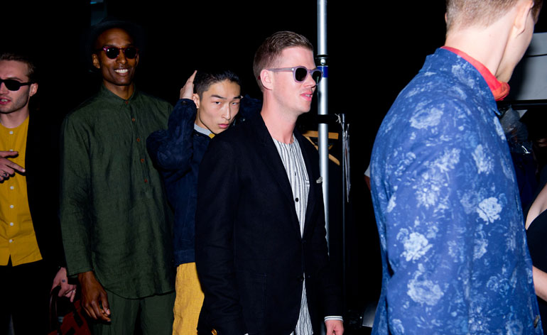 Male models wearing the Oliver Spencer S/S 2015 collection. They are all standing in a row as if they are going to parade any moment