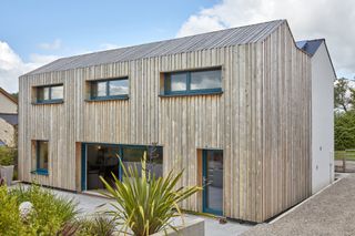 timber clad self build with two pitched roof and solar panels