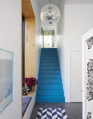 Painted blue staircase in small white hallway