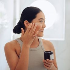 Rosalique - woman applying cream to cheeks