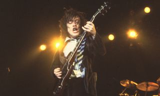 Angus Young performs live with AC/DC in 1983
