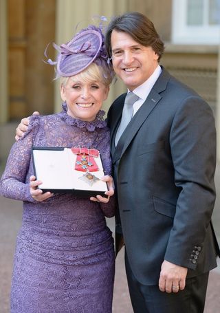 Television star Barbara Windsor with husband Scott Mitchell after she was made a Dame Commander of the order of the British Empire by Queen Elizabeth II during an Investiture ceremony at Buckingham Palace, London. (John Stillwell/PA Wire)