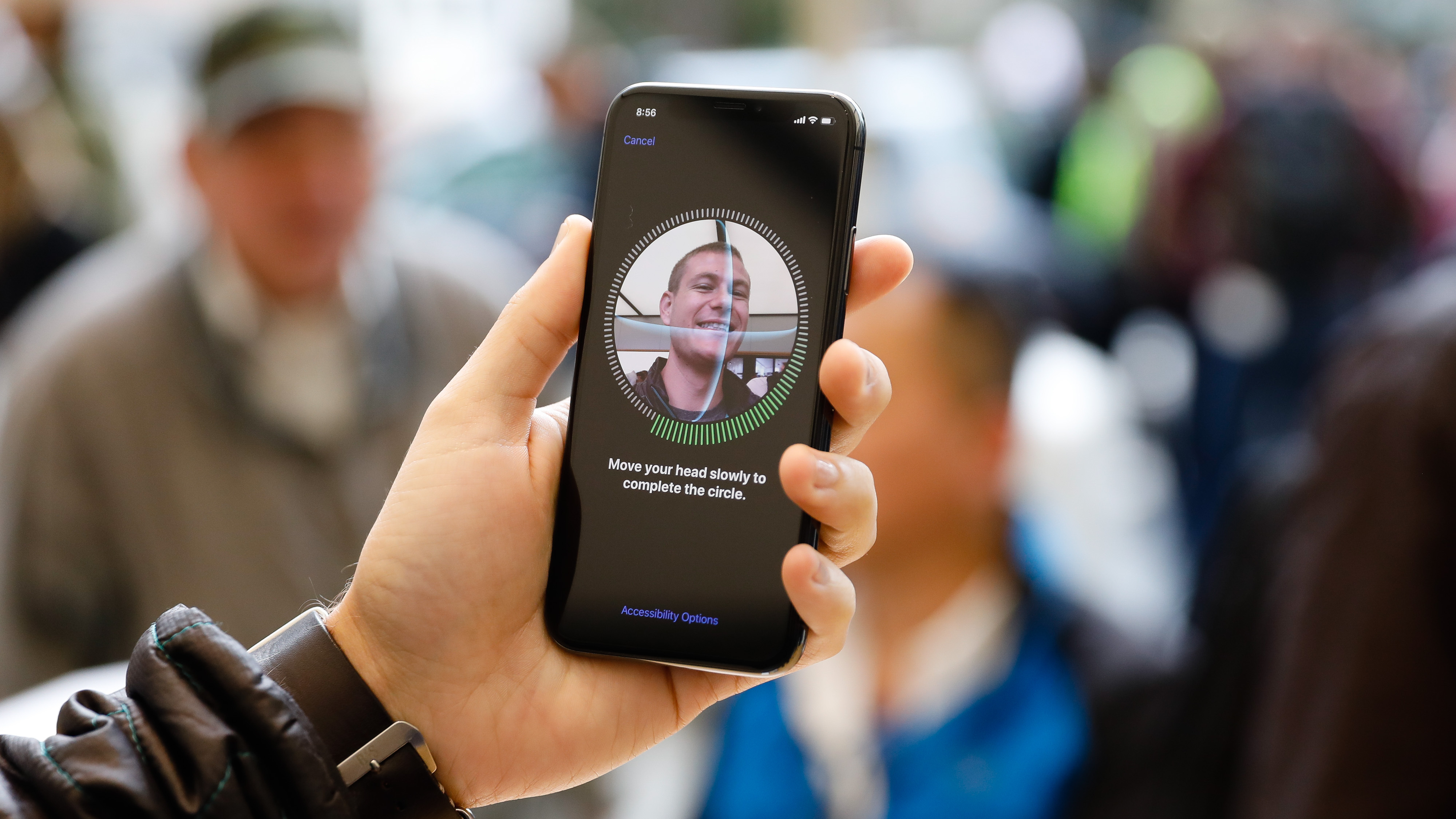 Person holding the iPhone X, setting up Face ID