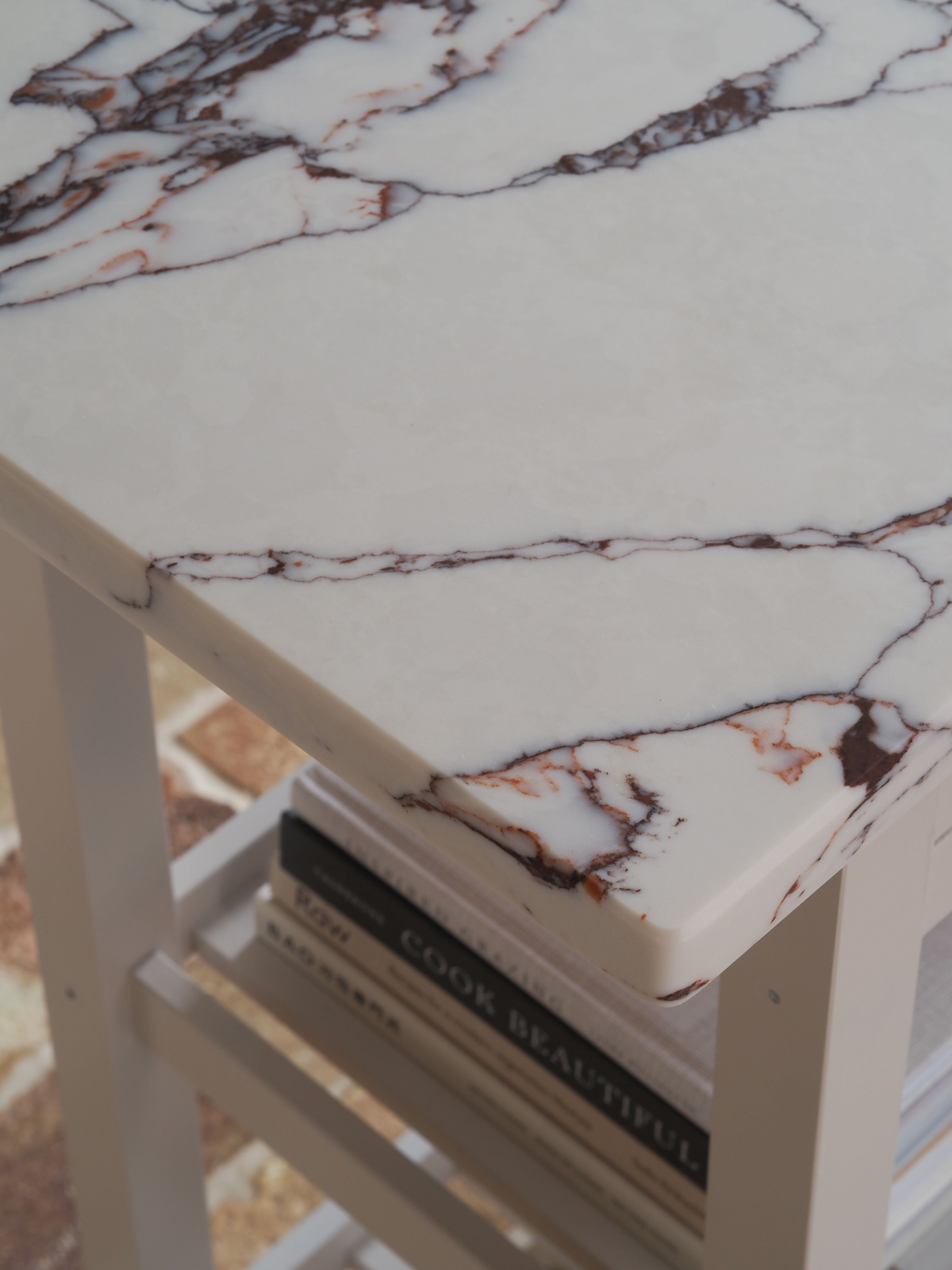 a close up of a neutral kitchen island with a marble top