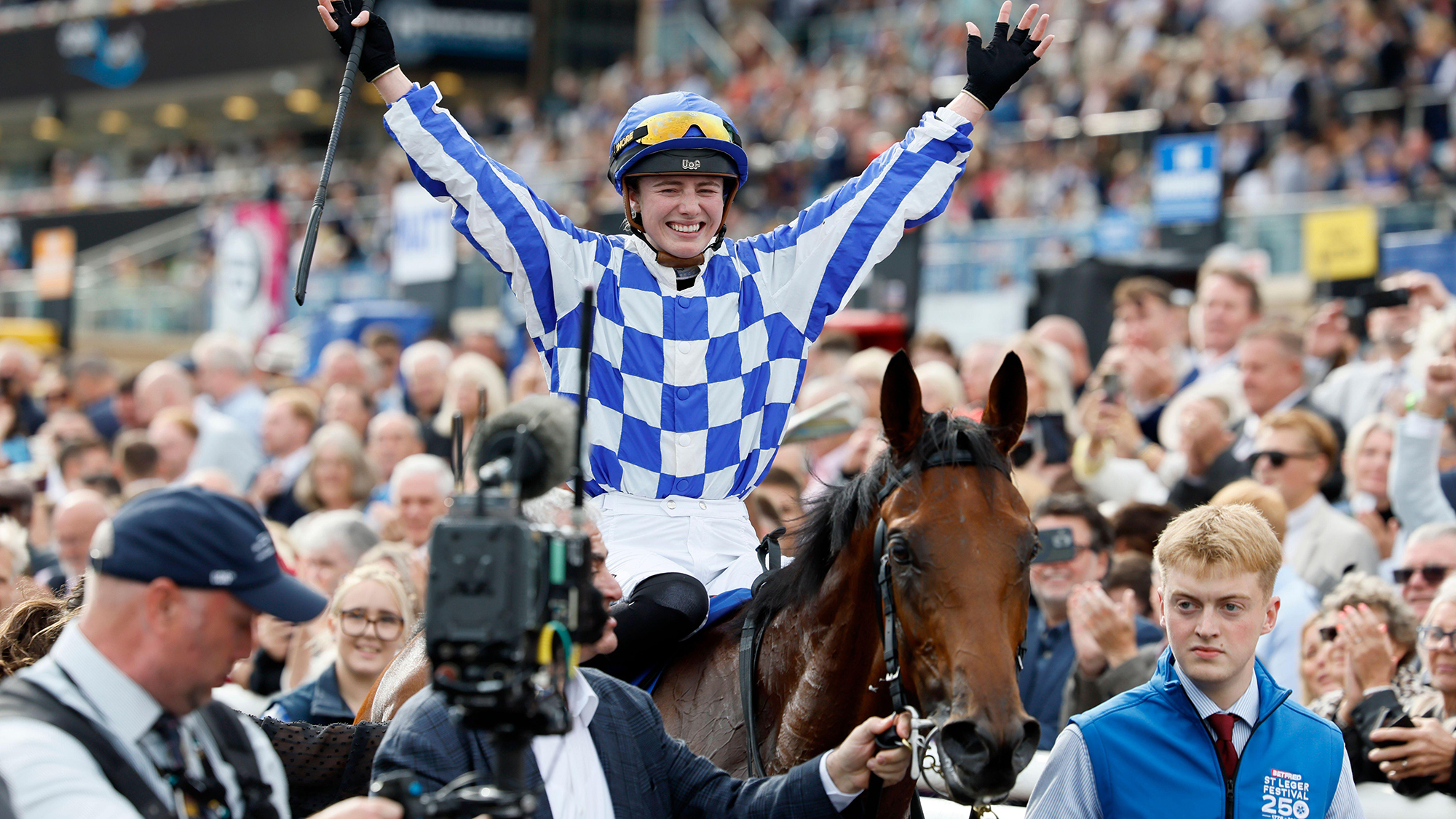 Saffie Osborne hold her arms aloft to celebrate after winning the Betfred St Leger Stakes at Doncaster on Saturday 12 September 2026 as she walks back in on Highwayman
