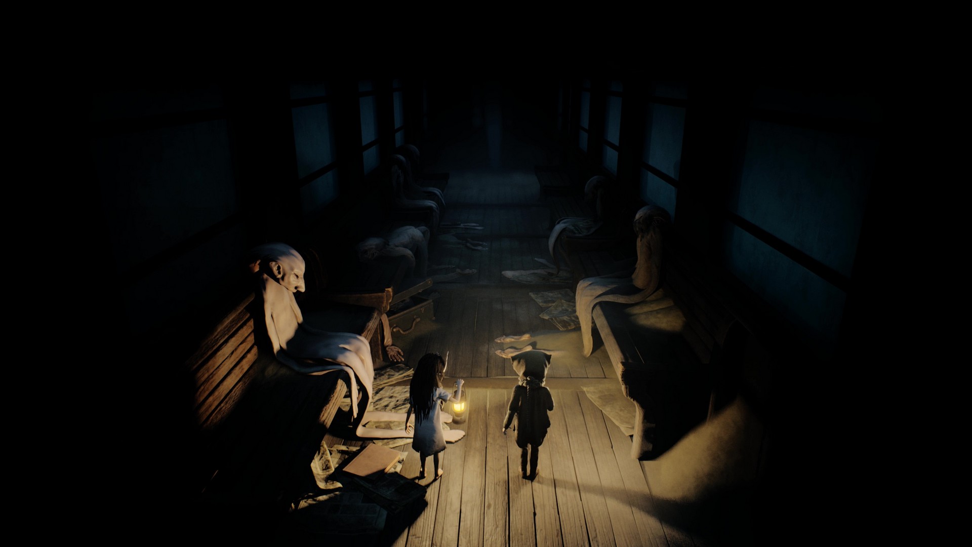 The siblings stand in a train carriage, lighting nearby empty human skin around them in Reanimal
