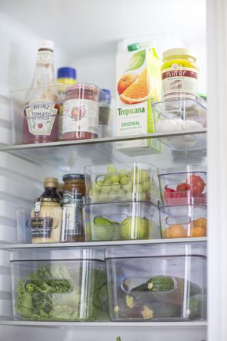 open fridge with food stored in clear stackable containers