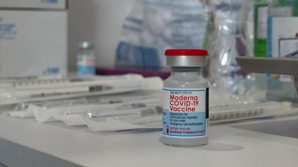 vial of moderna covid-19 vaccine on a table