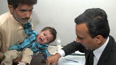 Nine-month-old, Mohammad Musa, has his fingerprints taken by a Pakistani lawyer
