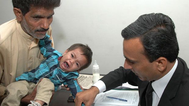 Nine-month-old, Mohammad Musa, has his fingerprints taken by a Pakistani lawyer