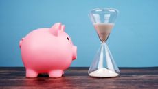 A piggy bank staring at an hour glass
